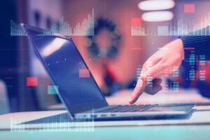 eine Hand tippt auf einen Laptop